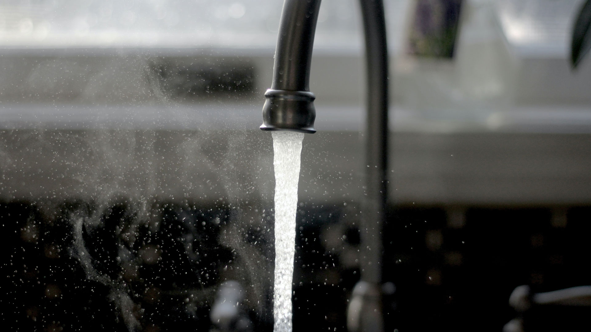 A photo of a faucet with water running.